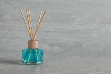 Photo of Aromatic reed freshener on grey table, space for text