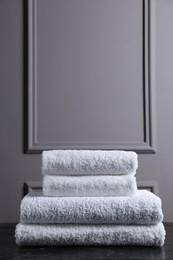 Stacked terry towels on black textured table indoors, space for text