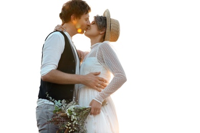 Photo of Happy newlyweds with beautiful field bouquet kissing outdoors