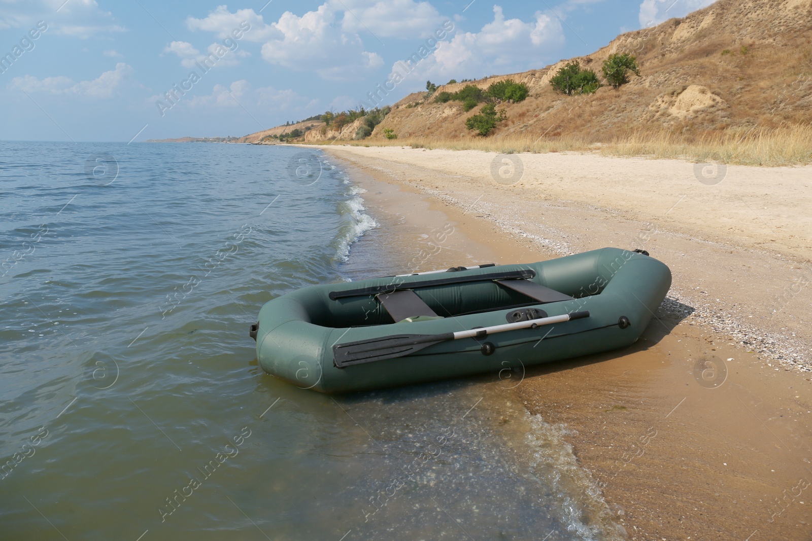 Photo of Inflatable rubber fishing boat on sandy beach near sea