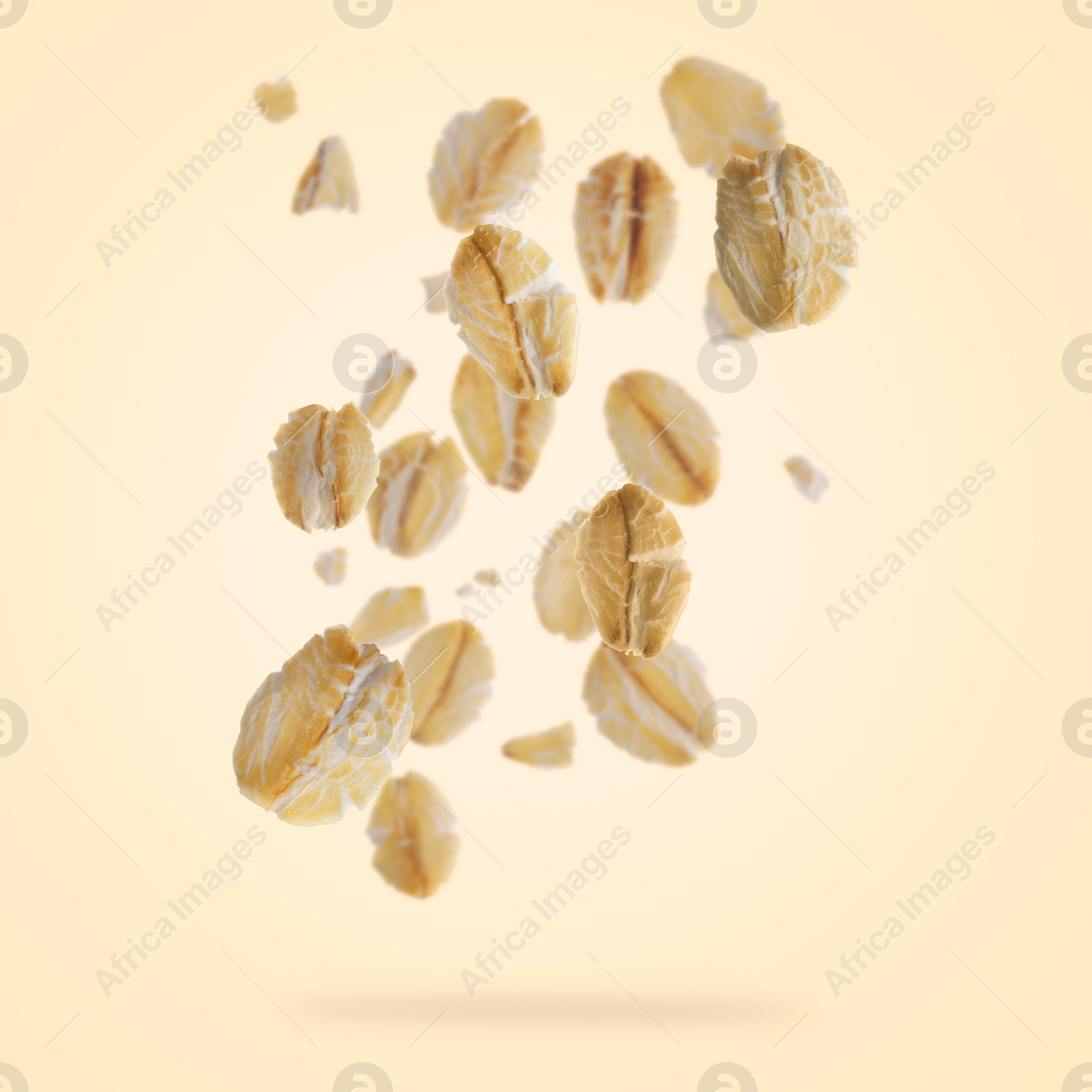 Image of Rolled oat flakes falling on beige background