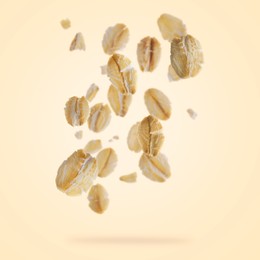 Image of Rolled oat flakes falling on beige background