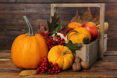 Photo of Happy Thanksgiving day. Composition with pumpkins, berries and walnuts on wooden table, closeup