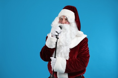 Santa Claus singing with microphone on blue background. Christmas music