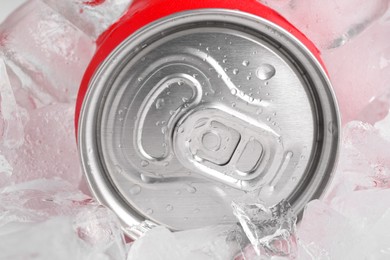 Photo of Energy drink in wet can and ice cubes, closeup