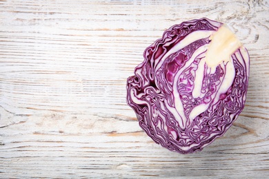 Photo of Half of ripe red cabbage on wooden  background, top view