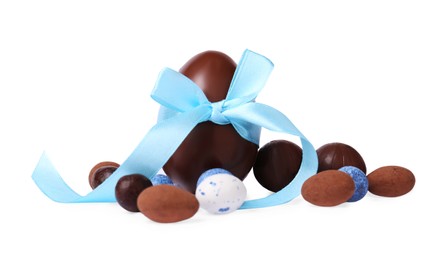 Photo of Tasty chocolate egg with color bow and candies isolated on white