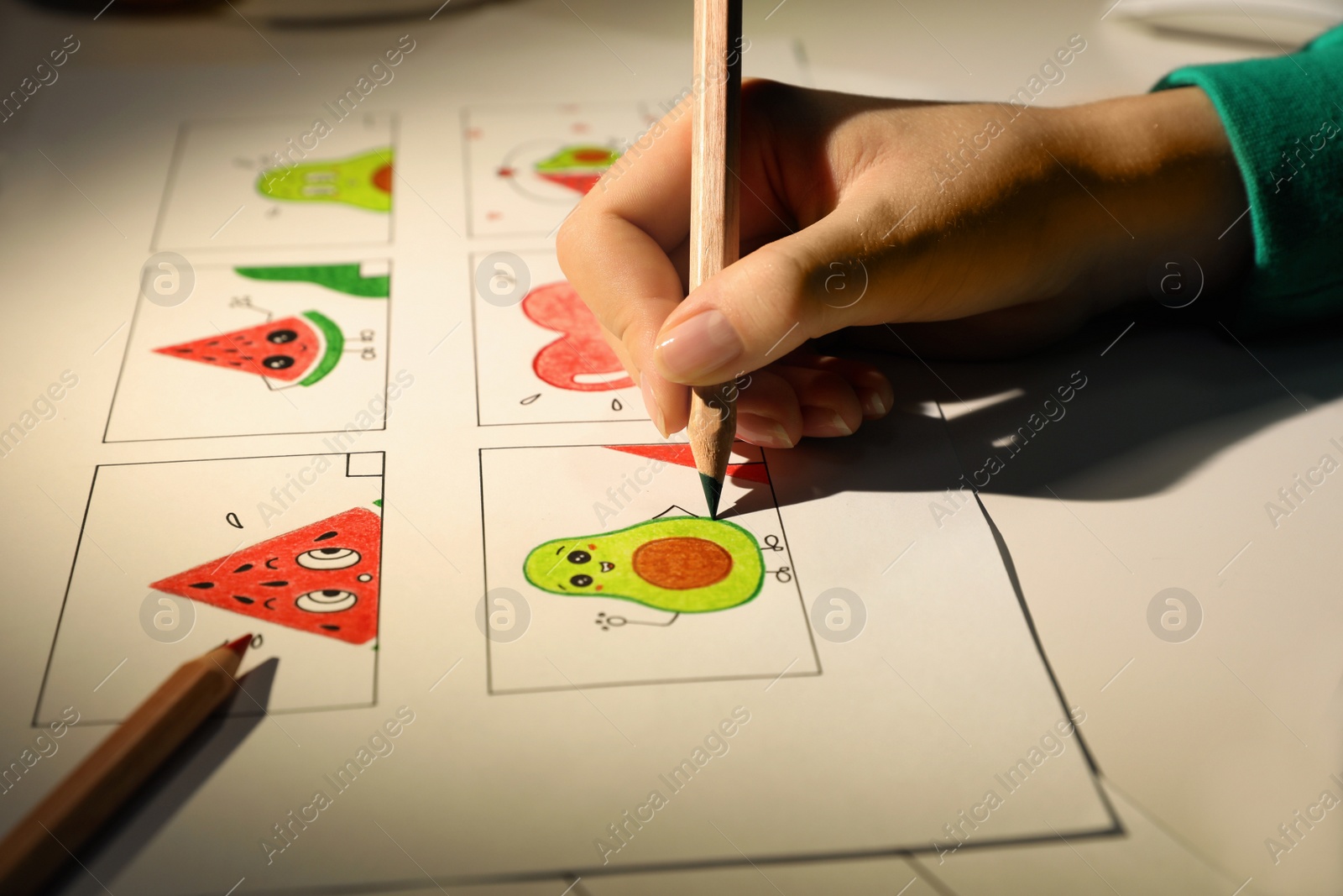 Photo of Woman drawing cartoon sketch at workplace, closeup. Pre-production process