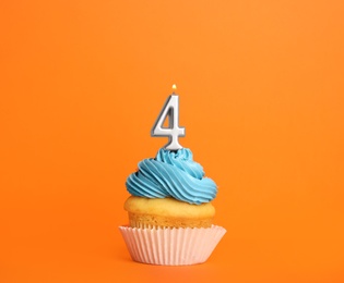 Photo of Birthday cupcake with number four candle on orange background