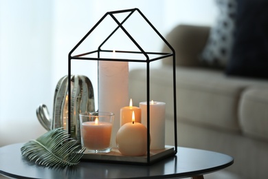 Burning candles on table against blurred background