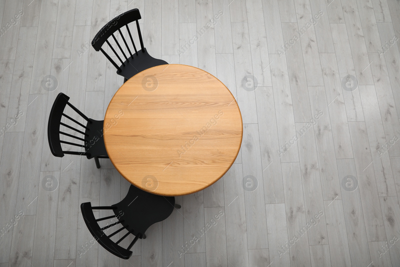 Photo of Stylish round table with black chairs on floor, top view. Space for text