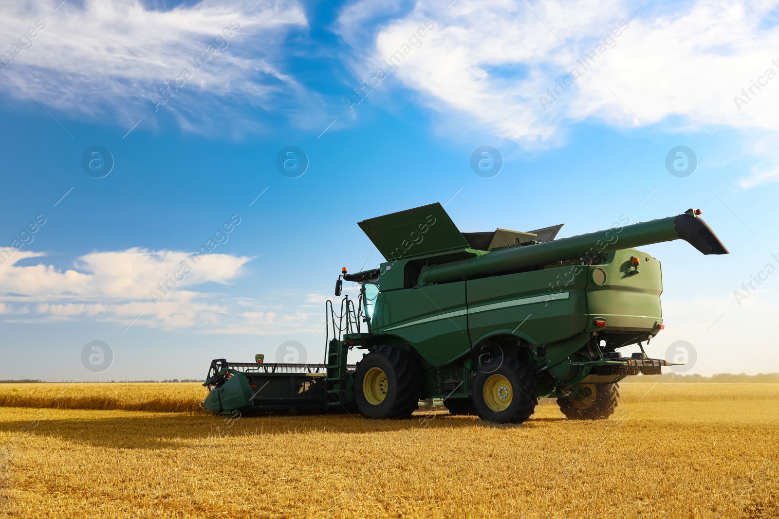 Photo of Modern combine harvester working in agricultural field