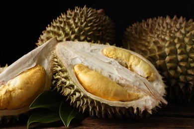 Photo of Fresh ripe durian fruits on wooden table, closeup