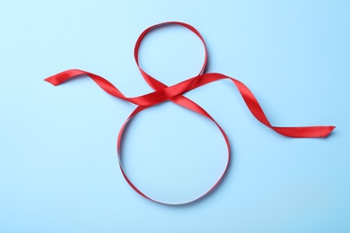 Photo of Number 8 of red ribbon on light blue background, top view. International Women's day