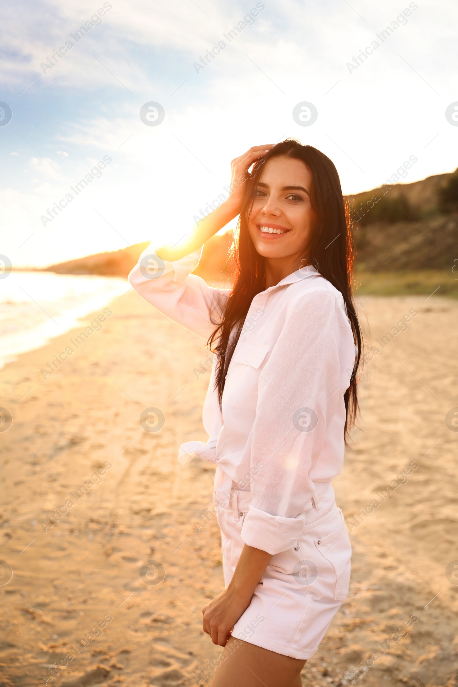 Photo of Young beautiful woman on beach at sunset