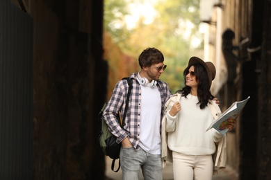 Couple of travelers with map on city street