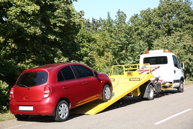 Photo of Broken car and tow truck on country road