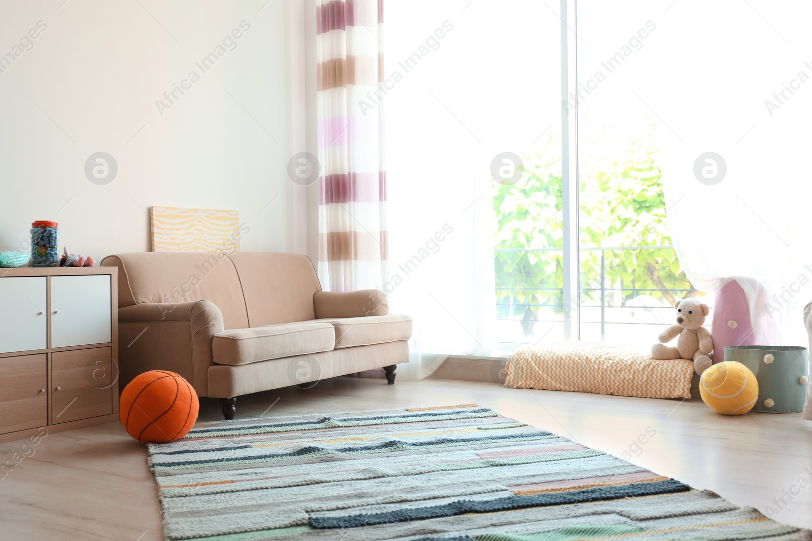 Photo of Stylish child room interior with comfortable sofa