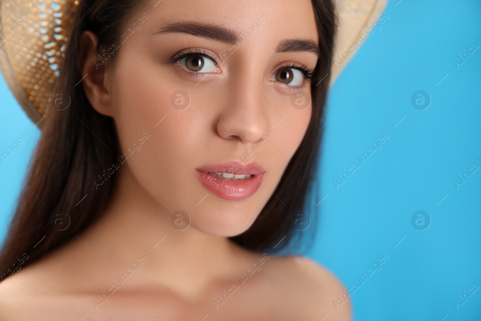 Photo of Portrait of beautiful young woman on light blue background, closeup