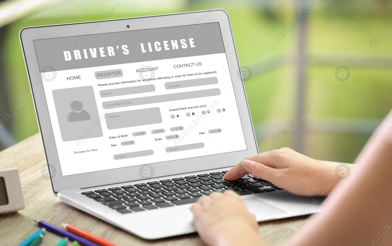 Image of Woman filling in driver's license form online on website using laptop, closeup