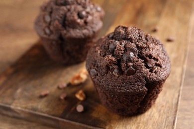 Photo of Delicious chocolate muffins on wooden table, closeup
