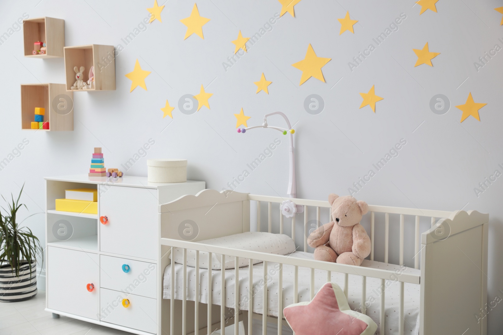 Photo of Stylish baby room interior with crib and toys