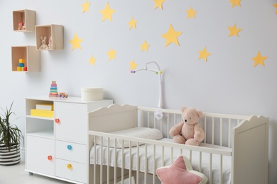 Stylish baby room interior with crib and toys