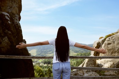 Photo of Woman feeling freedom by enjoying mountain landscape, back view