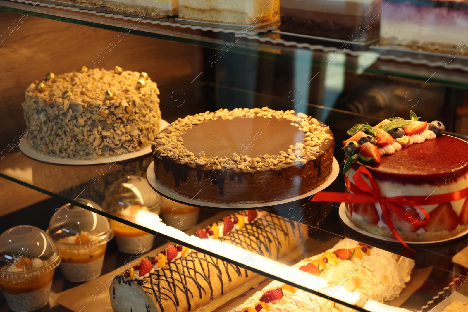 Photo of Different tasty desserts on counter in bakery shop, closeup