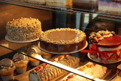 Photo of Different tasty desserts on counter in bakery shop, closeup