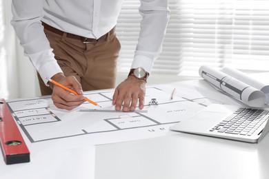 Architect working with construction drawings in office, closeup