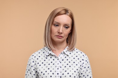 Portrait of sad woman on beige background