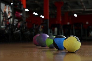 Photo of Medicine balls on floor in gym. Space for text