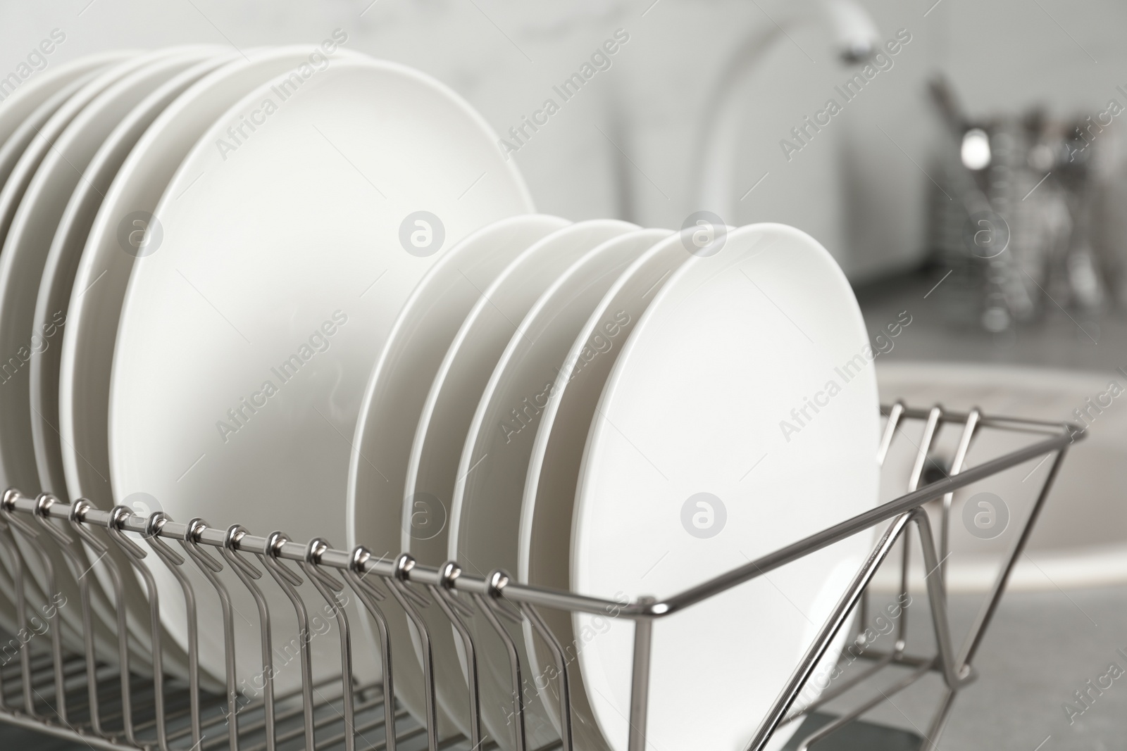 Photo of Drying rack with clean dishes on kitchen counter