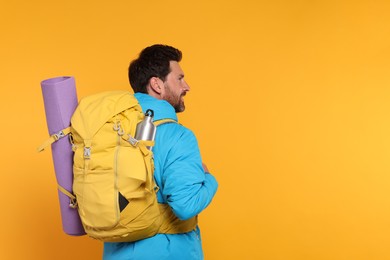 Photo of Man with backpack on orange background, space for text. Active tourism