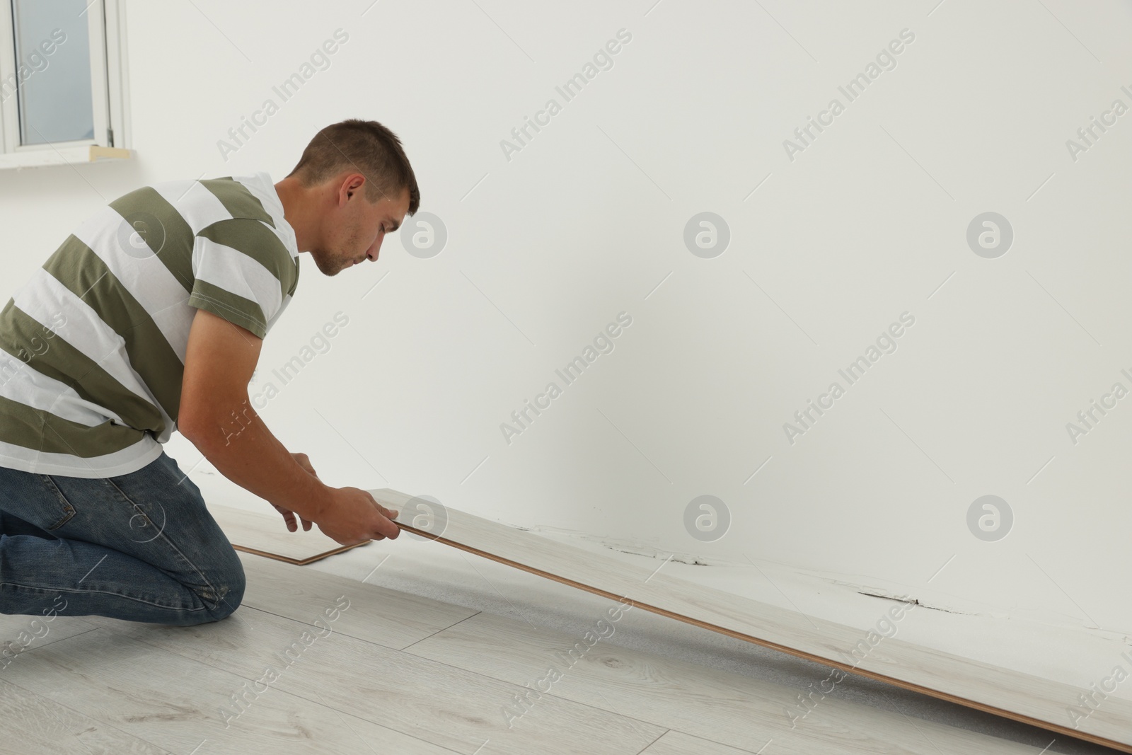 Photo of Professional worker installing new laminate flooring indoors