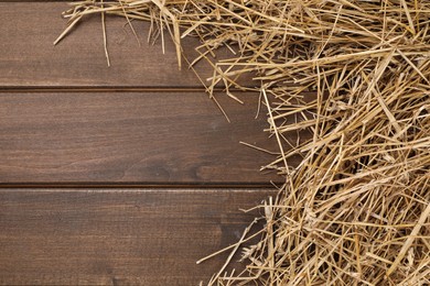 Photo of Dried straw on wooden table, space for text