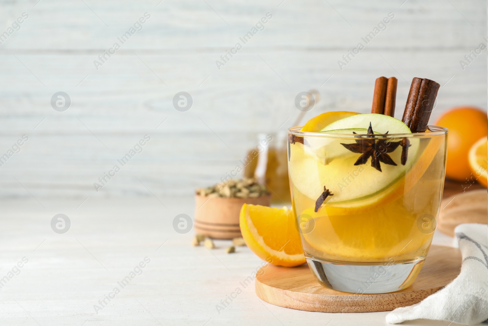 Photo of Aromatic white mulled wine on wooden table. Space for text