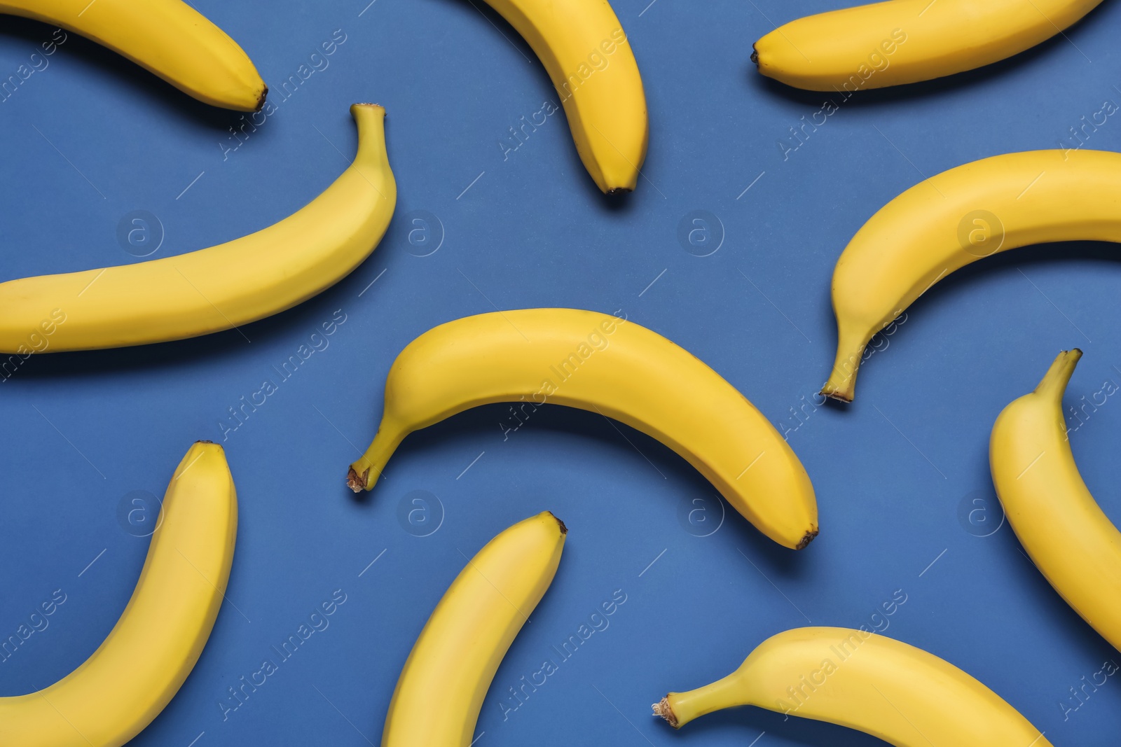 Photo of Ripe yellow bananas on blue background, flat lay