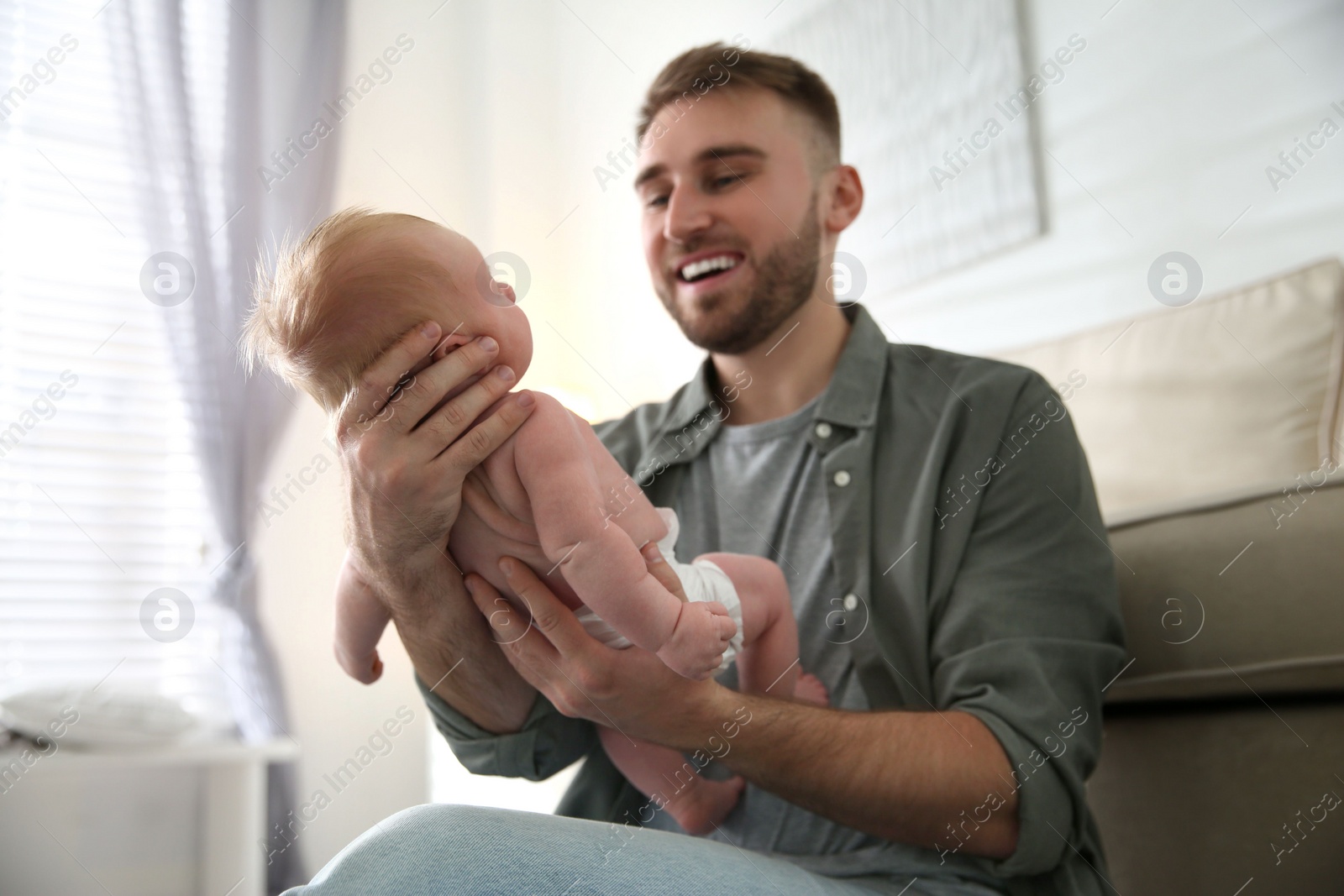 Photo of Father with his newborn son at home