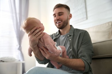 Photo of Father with his newborn son at home