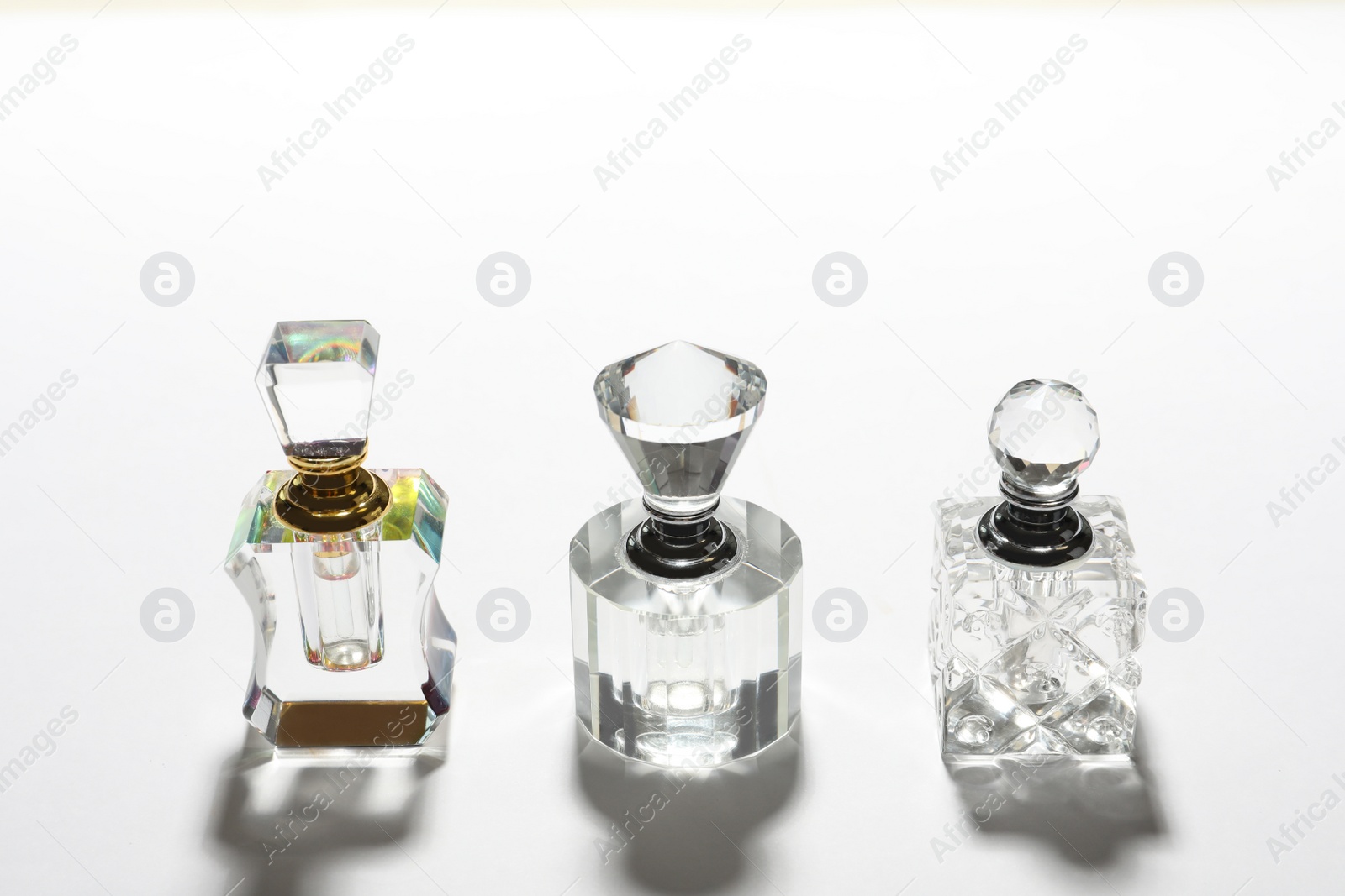 Photo of Different elegant perfume bottles on white background