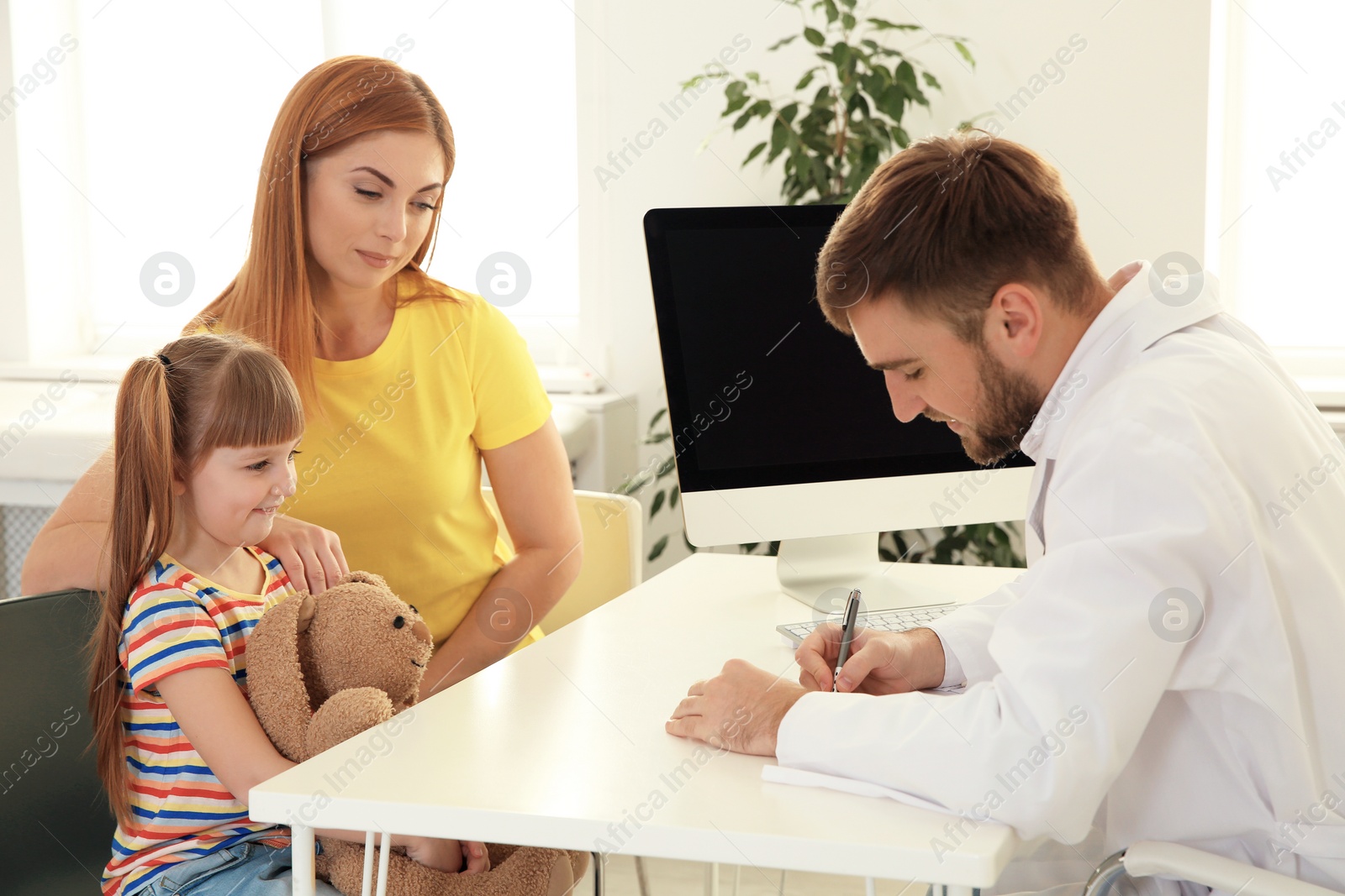 Photo of Mother and daughter visiting pediatrician. Doctor working with patient in hospital