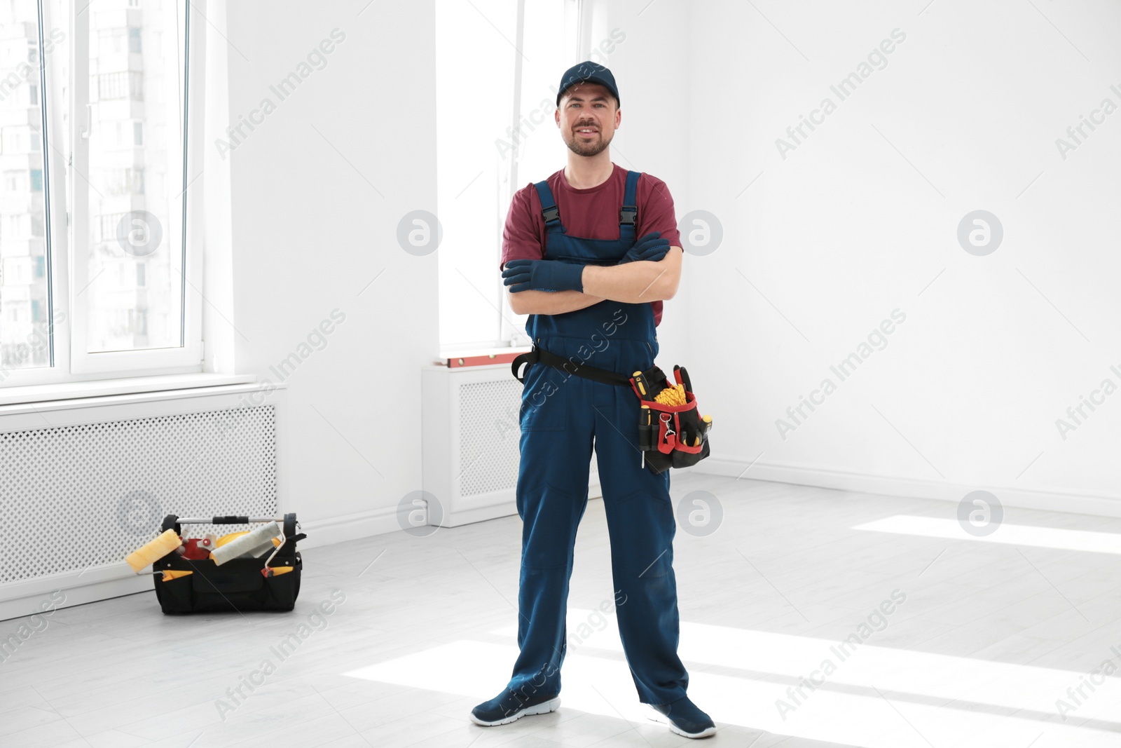 Photo of Full length portrait of professional construction worker with tool belt indoors