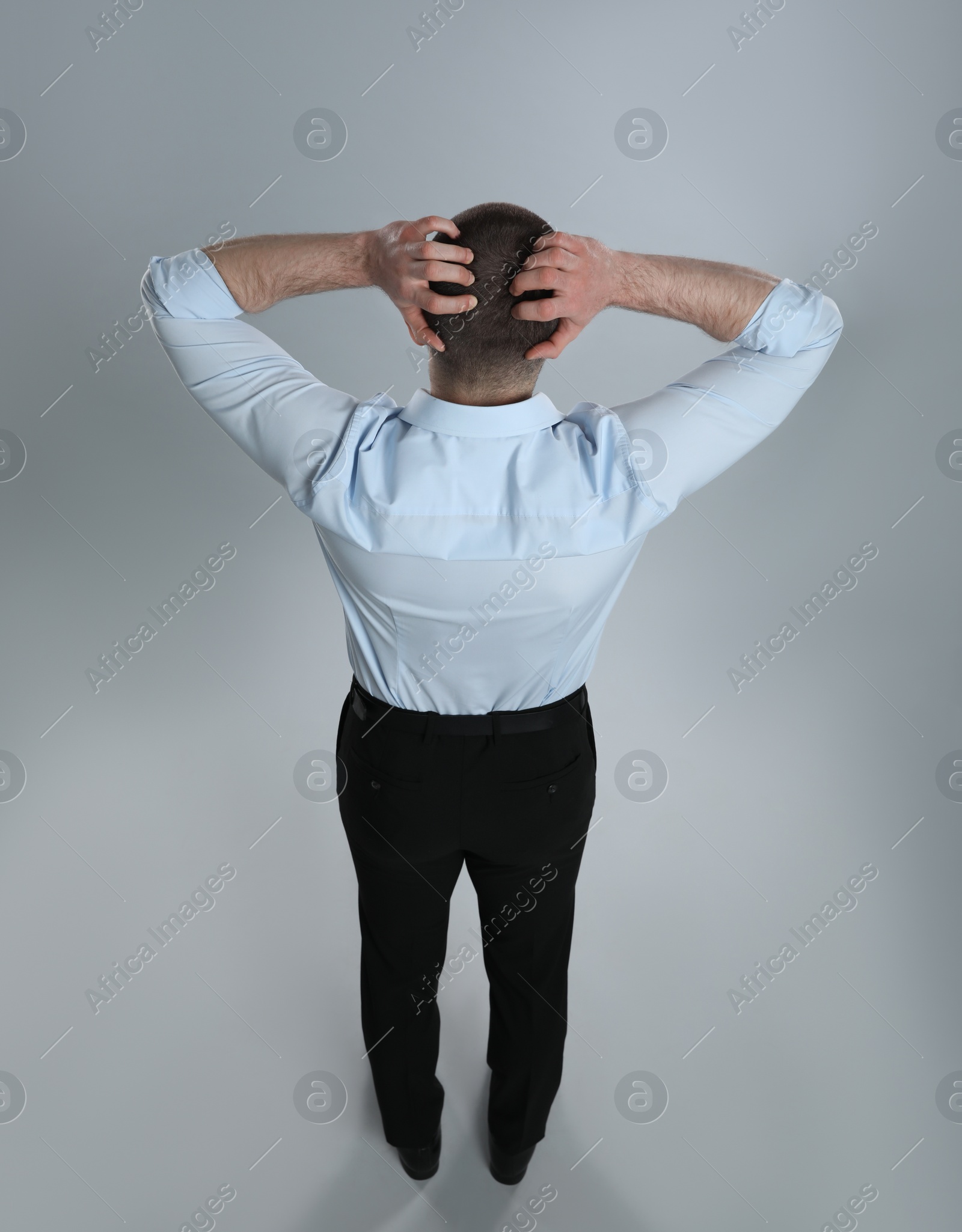 Photo of Man in formal clothes on grey background, back view