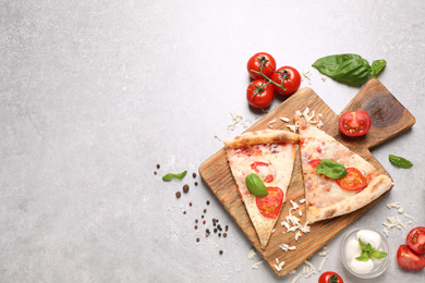 Photo of Slices of delicious pizza Margherita on light grey table, flat lay. Space for text