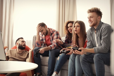 Emotional friends playing video games at home