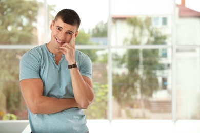 Portrait of handsome young man indoors. Space for text