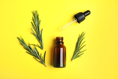 Photo of Flat lay composition with rosemary essential oil on yellow background