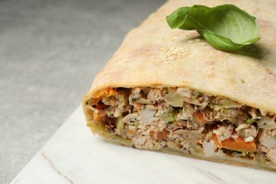 Delicious strudel with basil, chicken and vegetables on grey table, closeup